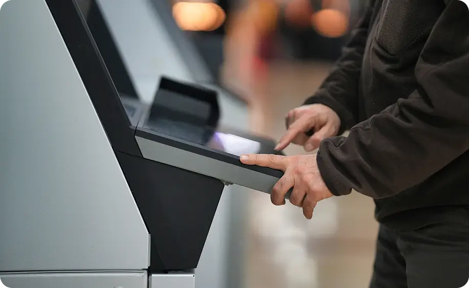 Person using a touchscreen kiosk by tapping options on the display
