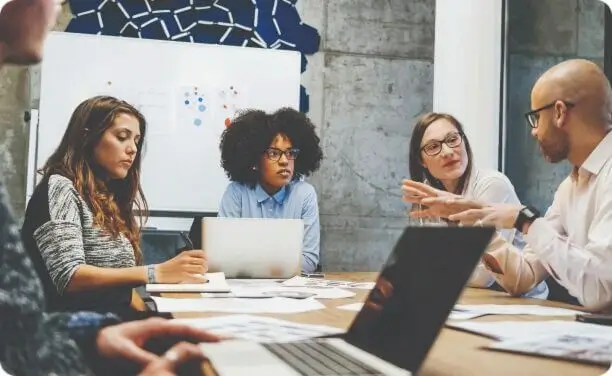 Team members collaborating on strategy and design in a conference room.