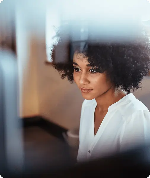 Woman viewing an analytics dashboard showing charts, percentages, and session data on a computer screen.