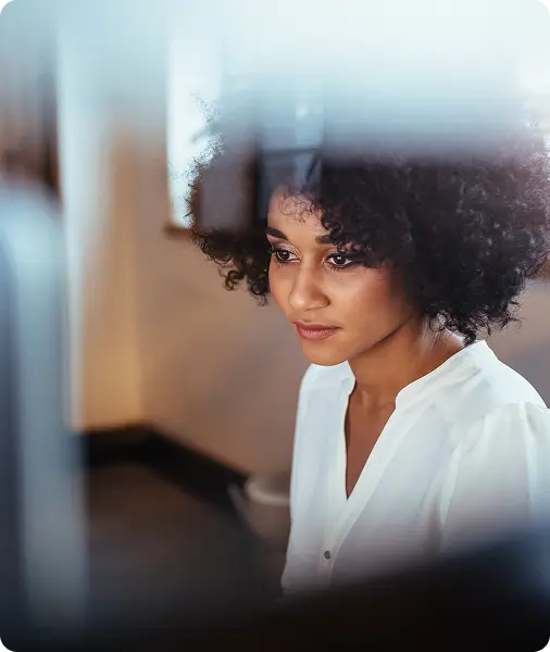 Analytics dashboard interface showing graphs and performance metrics beside a woman working at a computer.